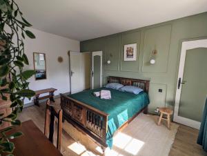 - une chambre avec un lit et une couette verte dans l'établissement Sweet Home Dordogne between Sarlat-Souillac, à Peyrillac-et-Millac