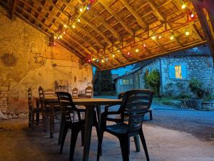 une table et des chaises en bois sous un toit éclairé dans l'établissement Sweet Home Dordogne between Sarlat-Souillac, à Peyrillac-et-Millac