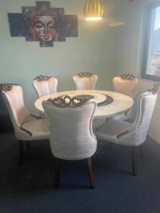 a dining room table with white chairs around it at New house in Kathmandu