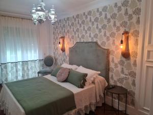 a bedroom with a bed with green and pink pillows at Casa A Pastora in Cambados