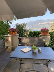 une table bleue et des chaises sur une terrasse fleurie dans l'établissement Bellagio Panorama, à Bellagio