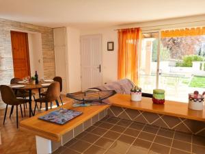 uma cozinha e sala de estar com mesa e cadeiras em Bas de villa avec Piscine et Terrasse au calme em Contes
