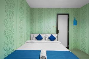 a bedroom with a bed with blue and green walls at HOUSE MUSE in Siantan