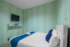 una camera da letto con un letto bianco e carta da parati verde di HOUSE MUSE a Siantan