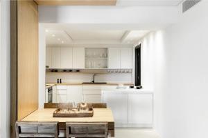a kitchen with white cabinets and a wooden table at Villa Adokerodes in Ornos