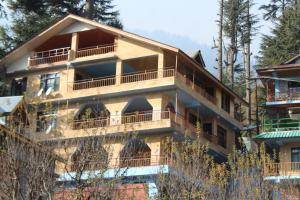 een groot gebouw met balkons aan de zijkant bij Guruchhaya hotel and cottages in Manāli
