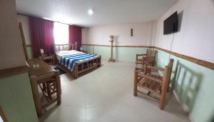 a room with a bed and a table and chairs at Hotel Casa Yaripa in Manizales