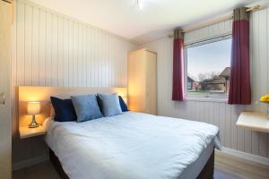 una camera da letto con un letto con cuscini blu e una finestra di Lodge -3 Bedrooms - Hunters Quay a Kilmun