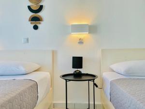 a room with two beds and a table with a lamp at Thalassa Garden Studios in Pefkohori