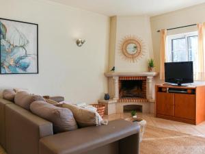 a living room with a couch and a fireplace at Joia da Galé House - Pool and Garden & BBQ & Galé Beach in Albufeira