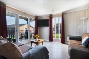 un soggiorno con divano e tavolo di Lodge -3 Bedrooms - Hunters Quay a Kilmun