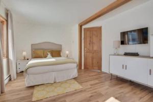 una grande camera da letto con un grande letto e pavimenti in legno di L'eau douce - Lumière naturelle en bord de lac a Saint-Donat-de-Montcalm