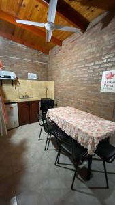 ein Zimmer mit einem Tisch, Stühlen und einer Ziegelwand in der Unterkunft Cabañas los álamos in Termas de Río Hondo