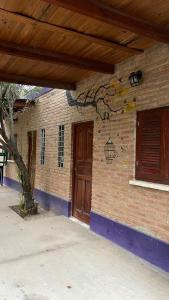 ein Backsteingebäude mit einer Holztür und einem Fenster in der Unterkunft Cabañas los álamos in Termas de Río Hondo