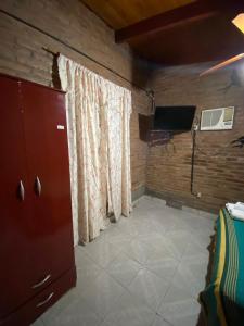 Zimmer mit einem Vorhang und einem TV in einem Zimmer in der Unterkunft Cabañas los álamos in Termas de Río Hondo