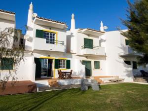 a large white house with green shutters at Joia da Galé House - Pool and Garden & BBQ & Galé Beach in Albufeira
