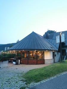 a building with a black roof on top of it at Útulna Craft - penzion Veronika in Pec pod Sněžkou