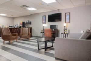 una sala de espera con muebles y TV de pantalla plana. en Microtel Inn & Suites by Wyndham Pigeon Forge, en Pigeon Forge