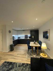een woonkamer met een tafel en stoelen en een keuken bij The Velvet Vista in Croydon