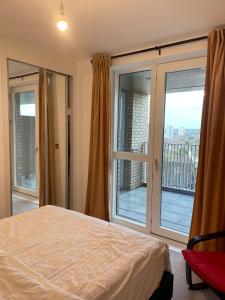 een slaapkamer met een bed en een groot raam bij The Velvet Vista in Croydon