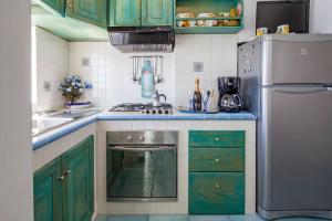 a kitchen with green cabinets and a refrigerator at Divina Costiera Praiano in Praiano