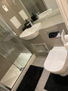 een badkamer met een toilet en een wastafel bij The Velvet Vista in Croydon