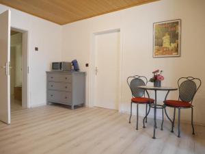 a room with a table and chairs and a cabinet at Renovierte Ferienwohnung in Pfuhl mit Terrasse in Nistertal