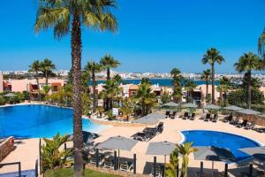 a view of the pool at a resort with palm trees at Casa Ferraguido by Portucasa in Ferragudo