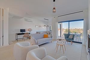 a living room with a couch and chairs at Casa Ferraguido by Portucasa in Ferragudo