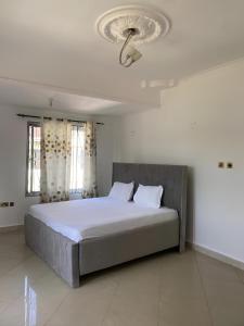 a bedroom with a large bed with a ceiling at Lema Luxe Villa - Bahari Beach, Dar Es Salam in Dar es Salaam