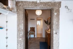 an open doorway into a room with a table and a chair at Refugio d'Alma in Mafra
