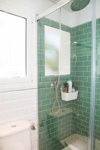 サロウにあるVilla Paula Trinidadの緑のタイル張りのバスルーム(ガラス張りのシャワー付)