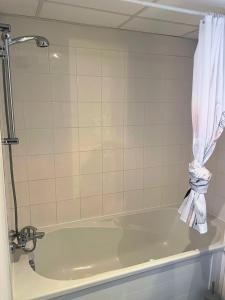 a bath tub in a bathroom with a curtain at [Rêve Rose] Studio Équipé, Wifi, Vue in Lourdes