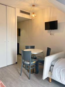 a living room with a table and a chair at [Rêve Rose] Studio Équipé, Wifi, Vue in Lourdes +14 photos