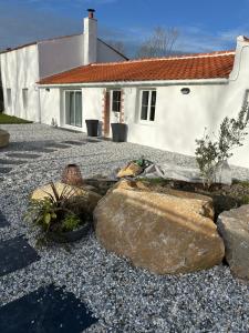 una casa con un jardín de rocas frente a una casa en Terre Do Maro, en Le Perrier