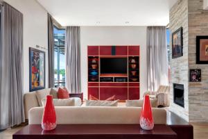 a living room with a couch and a tv at African Pride Melrose Arch, Autograph Collection in Johannesburg