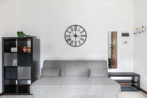 a couch in a living room with a clock on the wall at Casa Miri - Padova in Padova