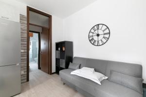 a living room with a couch and a clock on the wall at Casa Miri - Padova in Padova