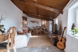 a living room with a couch and a guitar at Refugio d'Alma in Mafra