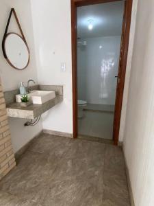 y baño con lavabo, aseo y espejo. en Anexo Canadense - Pousada Mineira SJB, en São João da Barra