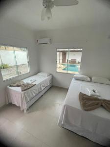 1 dormitorio con 2 camas y piscina en Anexo Canadense - Pousada Mineira SJB, en São João da Barra
