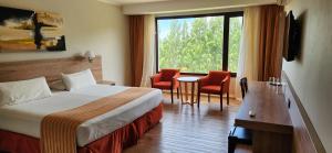 a hotel room with a bed and a table and chairs at Xelena Hotel & Suites in El Calafate