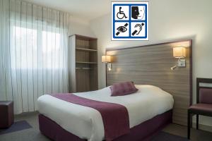 sypialnia z dużym łóżkiem i krzesłem w obiekcie Hôtel O'Nice Saintes w mieście Saintes