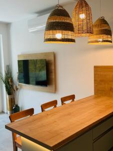 uma mesa de jantar com cadeiras e duas luzes pendentes em Fűzliget2- Bamboo em Balatonfuzfo