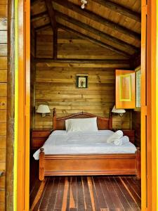een slaapkamer met een bed in een houten hut bij Hotel Karlaká Calarcá Quindio in Calarcá