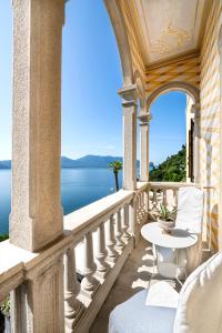 balcone con tavolo e vista sull'acqua di Hotel La Rondinella a Cannero Riviera