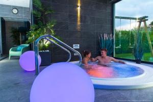 een man en een vrouw in een bubbelbad bij La Maison Blanche in Sangatte