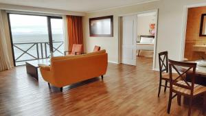 een woonkamer met een bank en een tafel bij Xelena Hotel & Suites in El Calafate