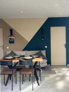 una sala da pranzo con un tavolo e un divano di Gîte du Pin avec Spa privatif a Pey