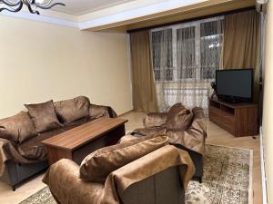 ein Wohnzimmer mit 2 Sofas und einem Flachbild-TV in der Unterkunft Home Sweet Home in Yerevan